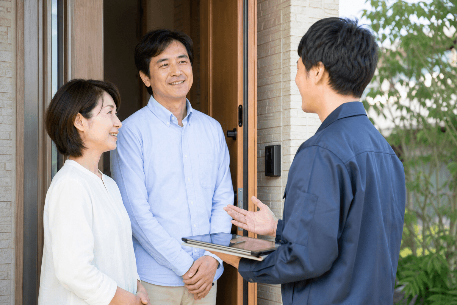 玄関先で住まいの相談をするスタッフ